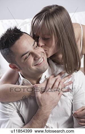Smiling couple kissing on couch View Large Photo Image Stock Photo - Smiling couple kissing on couch. Fotosearch