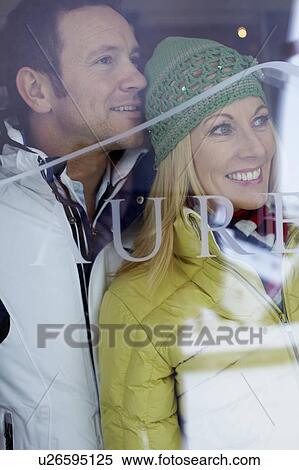 Smiling couple looking out window View Large Photo Image Stock Photography - Smiling couple looking out window. Fotosearch