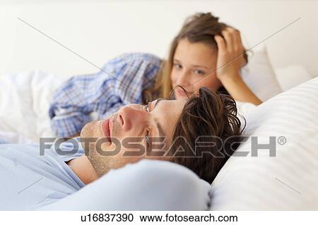 Smiling couple relaxing in bed View Large Photo Image Stock Image - Smiling couple relaxing in bed. Fotosearch