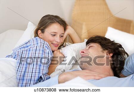 Smiling couple relaxing in bed View Large Photo Image Stock Photo - Smiling couple relaxing in bed. Fotosearch