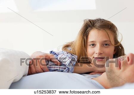 Smiling couple relaxing in bed View Large Photo Image Stock Photo - Smiling couple relaxing in bed. Fotosearch