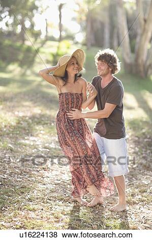 Stock Photo - Smiling couple walking in forest. Fotosearch