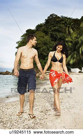Smiling couple walking together on beach View Large Photo Image Stock Photography - Smiling couple walking together on beach. Fotosearch