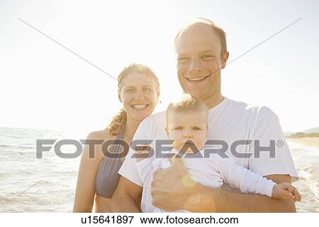 Smiling family standing on beach View Large Photo Image Stock Photo - Smiling family standing on beach. Fotosearch
