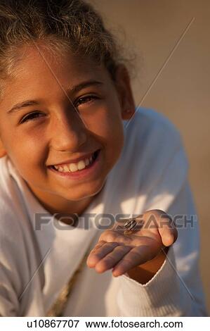 Smiling girl holding seashell View Large Photo Image Stock Photo - Smiling girl holding seashell. Fotosearch