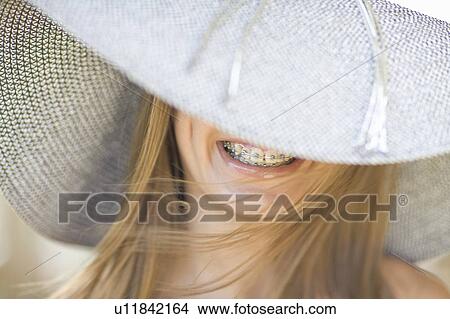 Picture - Smiling girl in braces wearing sunhat. Fotosearch