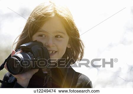 Smiling girl taking pictures outdoors View Large Photo Image Picture - Smiling girl taking pictures outdoors. Fotosearch