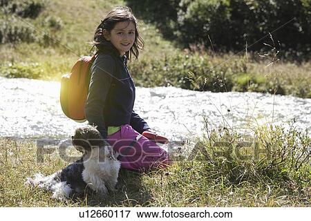 Smiling girl walking dog in field View Large Photo Image Stock Photo - Smiling girl walking dog in field. Fotosearch