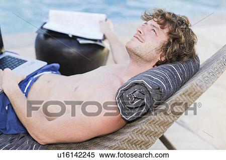 Smiling man using laptop by pool View Large Photo Image Stock Photography - Smiling man using laptop by pool. Fotosearch
