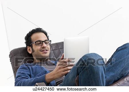 Smiling man using tablet computer View Large Photo Image Stock Image - Smiling man using tablet computer. Fotosearch