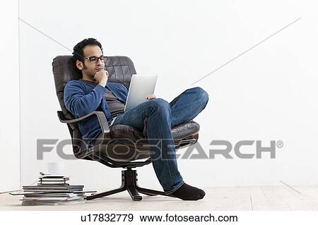 Stock Photo - Smiling man using tablet computer. Fotosearch