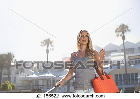 Smiling woman carrying purse on steps View Large Photo Image Stock Image - Smiling woman carrying purse on steps. Fotosearch