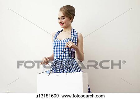Stock Photo - Smiling woman carrying shopping bag. Fotosearch