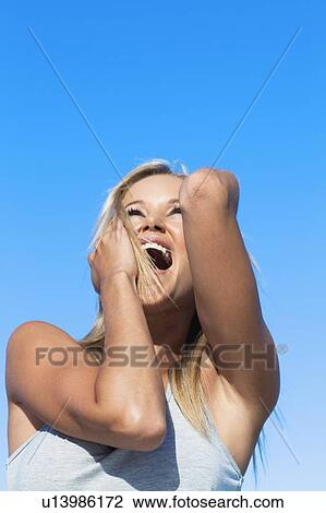 Smiling woman cheering outdoors View Large Photo Image Stock Image - Smiling woman cheering outdoors. Fotosearch
