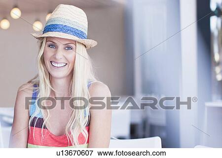 Smiling woman in sunhat sitting in cafe View Large Photo Image Stock Photo - Smiling woman in sunhat sitting in cafe. Fotosearch