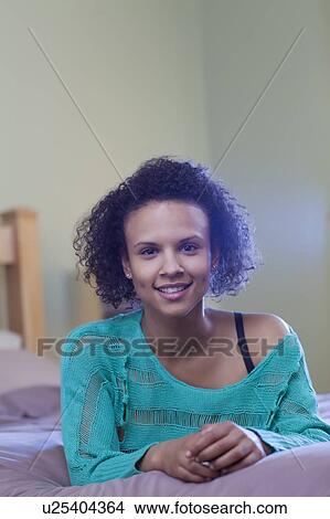 Smiling woman laying on bed View Large Photo Image Picture - Smiling woman laying on bed. Fotosearch