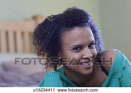Smiling woman laying on bed View Large Photo Image Stock Image - Smiling woman laying on bed. Fotosearch