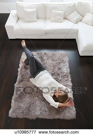 Smiling woman laying on rug View Large Photo Image Stock Photo - Smiling woman laying on rug. Fotosearch