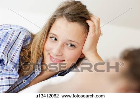 Smiling woman relaxing in bed View Large Photo Image Stock Image - Smiling woman relaxing in bed. Fotosearch