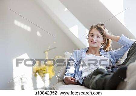 Smiling woman relaxing on sofa View Large Photo Image Stock Image - Smiling woman relaxing on sofa. Fotosearch