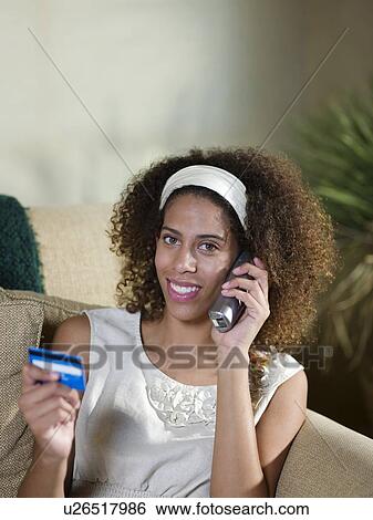 Smiling woman shopping on telephone View Large Photo Image Stock Photograph - Smiling woman shopping on telephone. Fotosearch