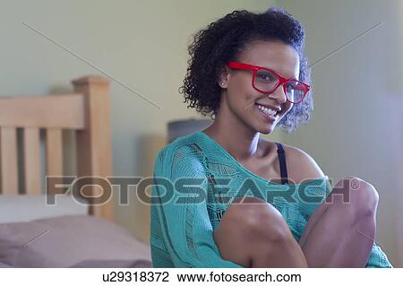 Smiling woman sitting on bed View Large Photo Image Stock Image - Smiling woman sitting on bed. Fotosearch