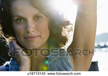 Stock Image - Smiling woman standing on pier. Fotosearch