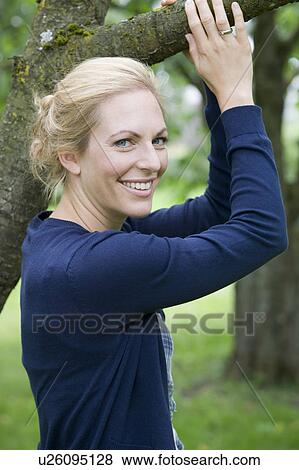Stock Photo - Smiling woman standing outdoors. Fotosearch