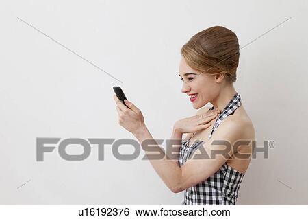 Smiling woman using cell phone View Large Photo Image Stock Photograph - Smiling woman using cell phone. Fotosearch
