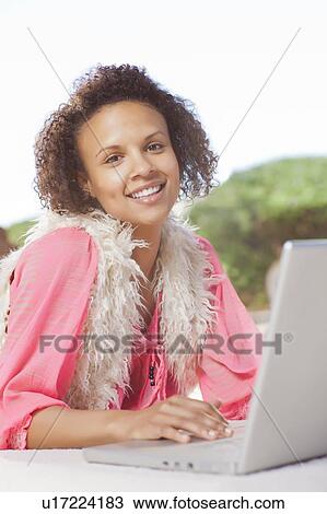 Smiling woman using laptop outdoors View Large Photo Image Stock Image - Smiling woman using laptop outdoors. Fotosearch