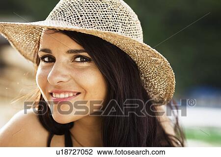 Stock Image - Smiling woman wearing sunhat. Fotosearch