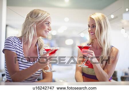 Smiling women having cocktails together View Large Photo Image Stock Photo - Smiling women having cocktails together. Fotosearch