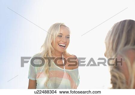 Smiling women talking outdoors View Large Photo Image Picture - Smiling women talking outdoors. Fotosearch