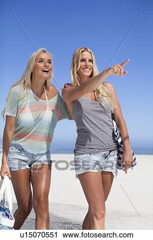 Smiling women walking together on beach View Large Photo Image Stock Image - Smiling women walking together on beach. Fotosearch