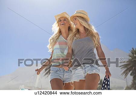 Picture - Smiling women walking together outdoors. Fotosearch
