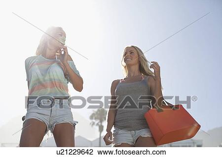 Smiling women walking together outdoors View Large Photo Image Stock Image - Smiling women walking together outdoors. Fotosearch
