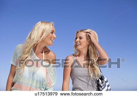 Stock Photo - Smiling women walking together outdoors. Fotosearch