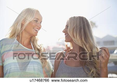 Smiling women walking together outdoors View Large Photo Image Stock Photograph - Smiling women walking together outdoors. Fotosearch
