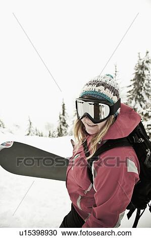 Snowboarder carrying board in snow View Large Photo Image Stock Image - Snowboarder carrying board in snow. Fotosearch