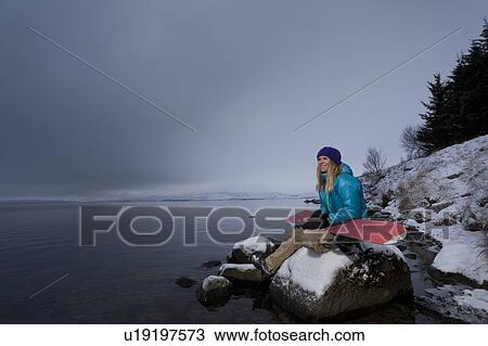 Snowboarder holding board by lake View Large Photo Image Stock Image - Snowboarder holding board by lake. Fotosearch