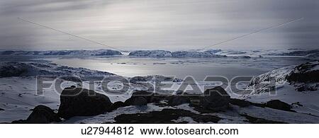 Stock Image - Still lake in snowy landscape. Fotosearch