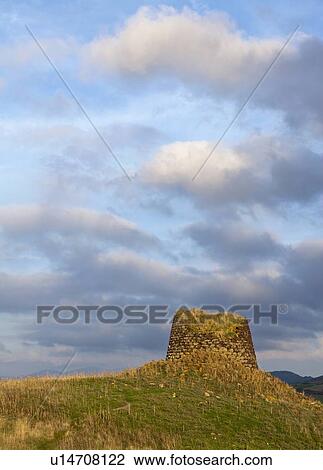Stock Image - Stone structure on grassy hill. Fotosearch