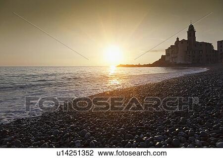 Sun setting over rocky beach View Large Photo Image Stock Image - Sun setting over rocky beach. Fotosearch