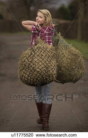 Teenage girl carrying hay on dirt path View Large Photo Image Stock Image - Teenage girl carrying hay on dirt path. Fotosearch