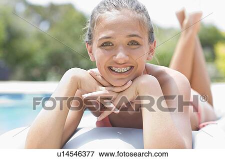 Teenage girl in braces relaxing by pool View Large Photo Image Stock Photo - Teenage girl in braces relaxing by pool. Fotosearch