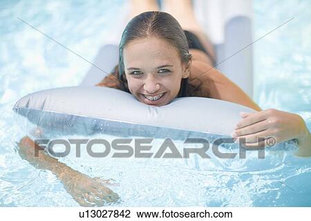 Teenage girl in braces relaxing in pool View Large Photo Image Stock Image - Teenage girl in braces relaxing in pool. Fotosearch