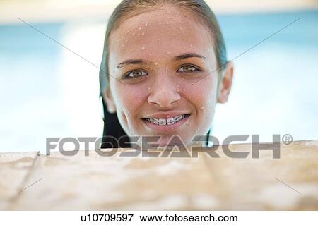 Teenage girl in braces relaxing in pool View Large Photo Image Stock Photo - Teenage girl in braces relaxing in pool. Fotosearch