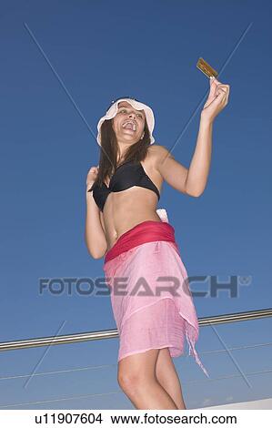 Picture - Teenage girl in braces with credit card. Fotosearch