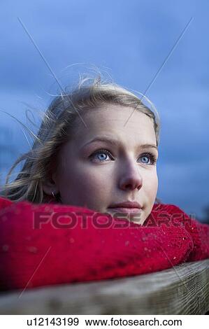 Stock Photo - Teenage girl leaning on wooden fence. Fotosearch