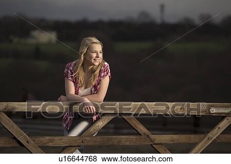 Teenage girl leaning on wooden fence View Large Photo Image Stock Photo - Teenage girl leaning on wooden fence. Fotosearch